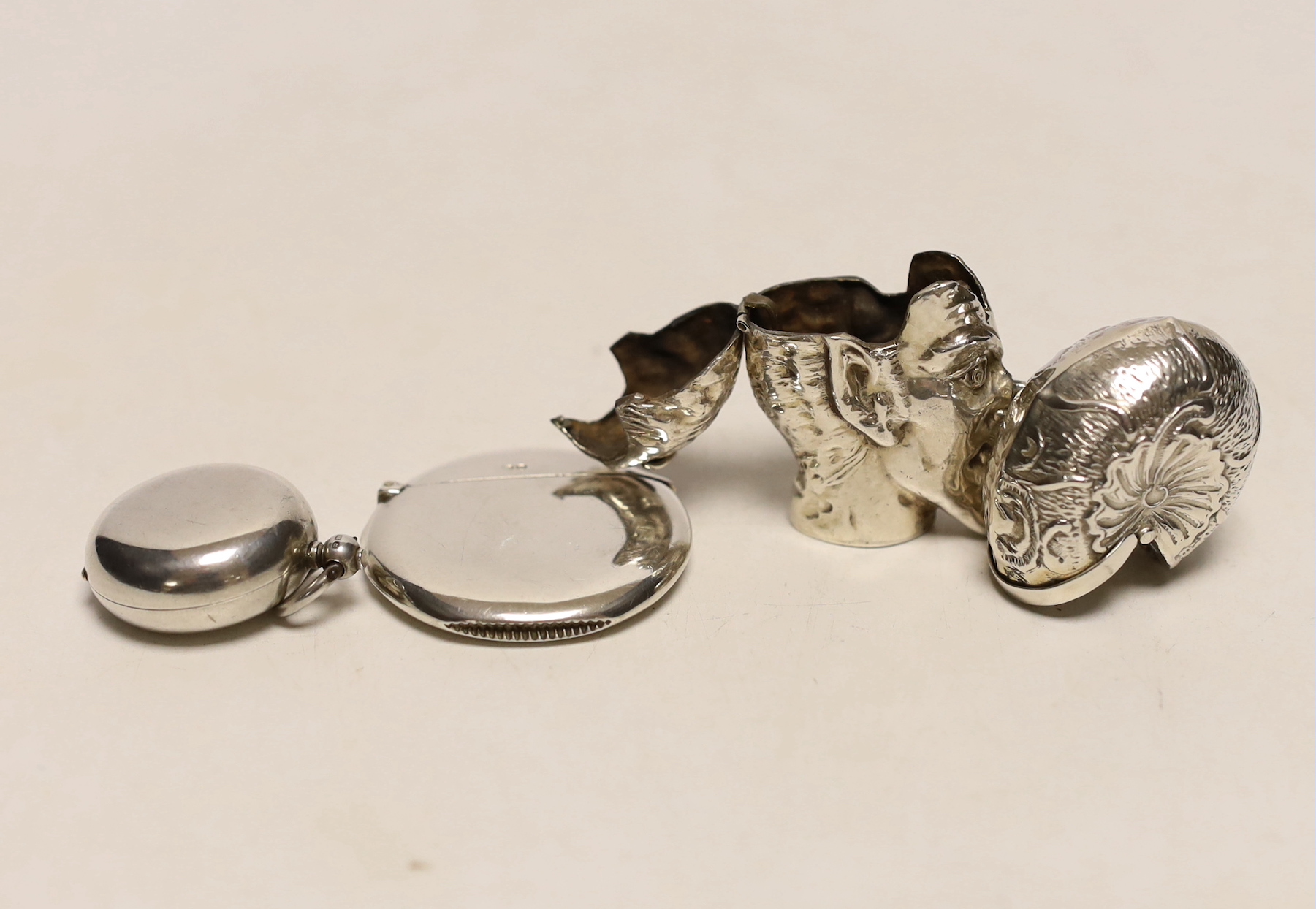 A late Victorian silver sovereign case, London, 1892, 30mm, a silver circular vesta, a white metal faun vesta and a shell box.